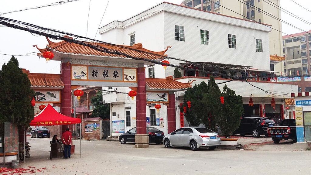 a picture showing the modern gate of the village along the main road