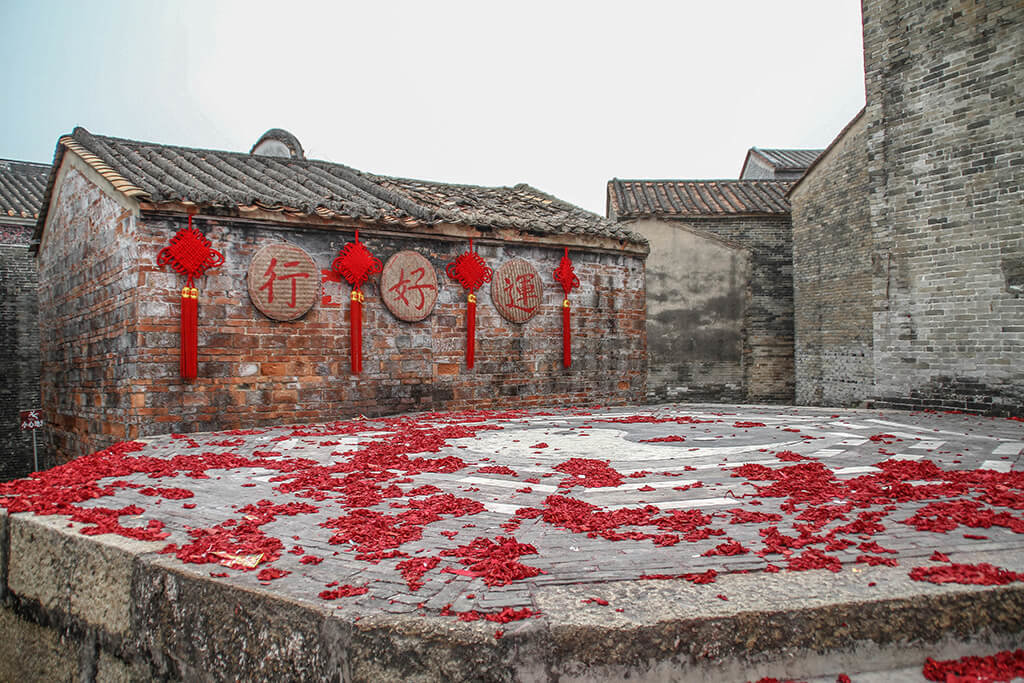 a picture showing the symbol of Ying and Yang on the central stone platform, covered with red firecrakers