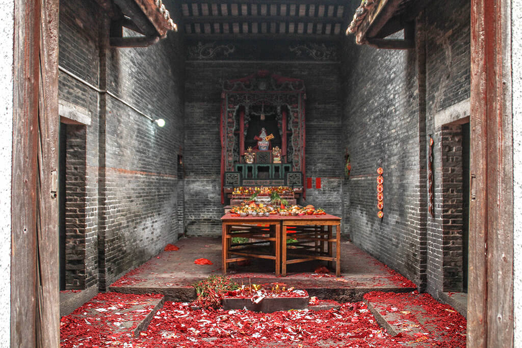 a picture showing fresh offerings on an altar between the houses